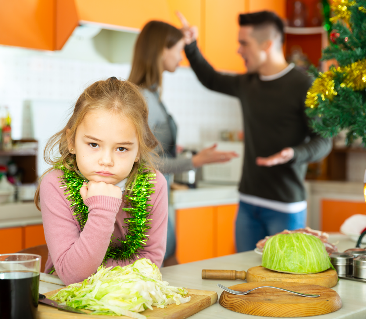 A child concerned as her parents fight behind her
