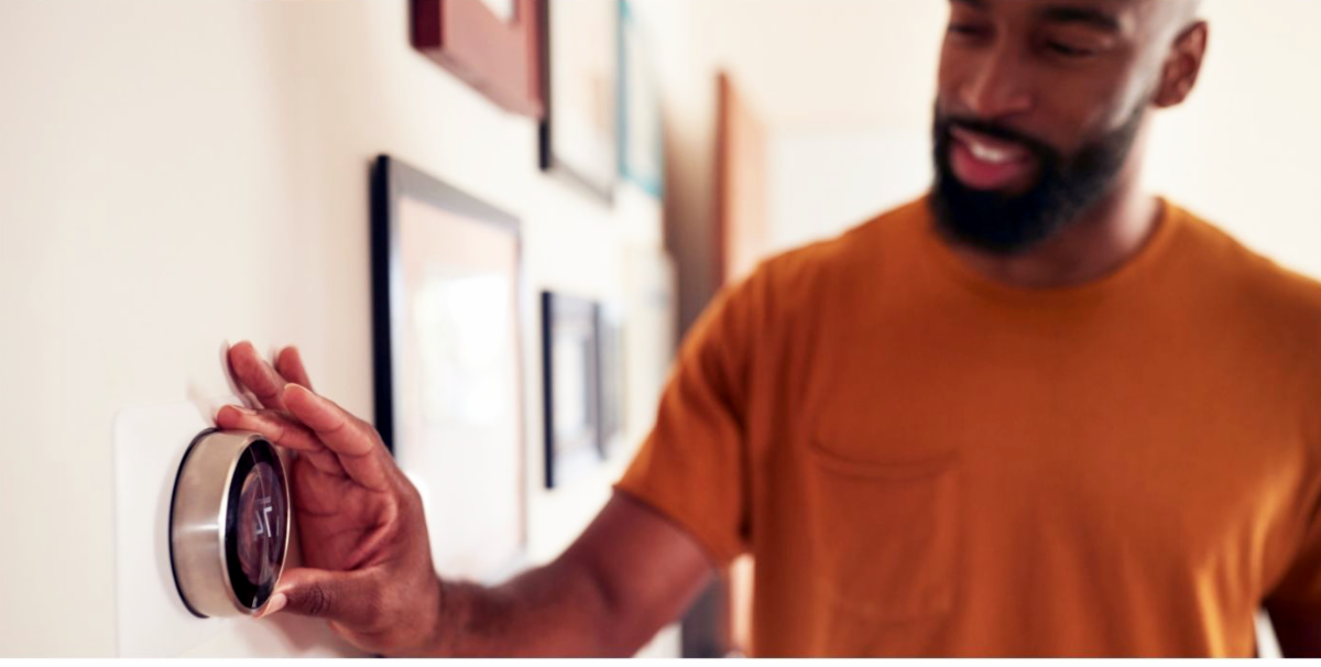 Man adjusting thermostat