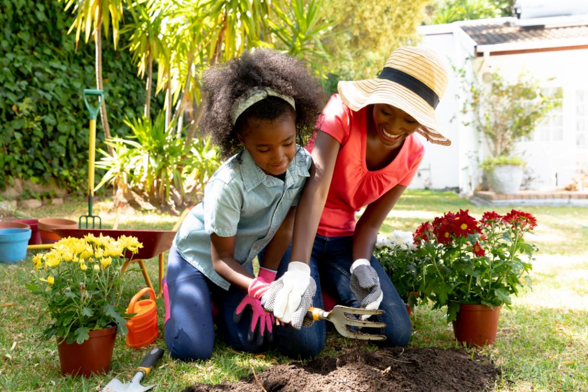 A mother and daughter planting a garden