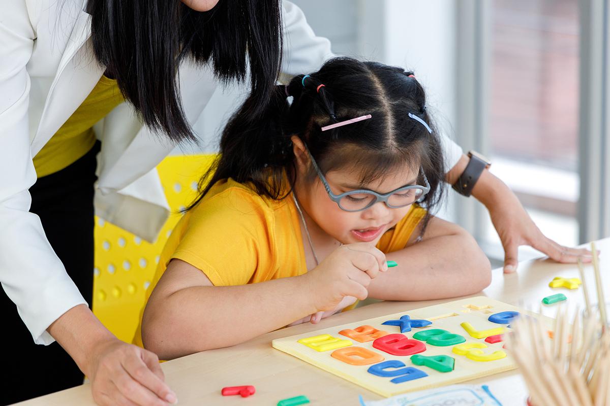 Girl with down syndrome learning letters