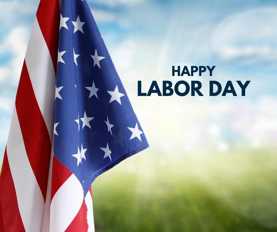 American flag against a bright blue sky and green field, with text reading 'Happy Labor Day.