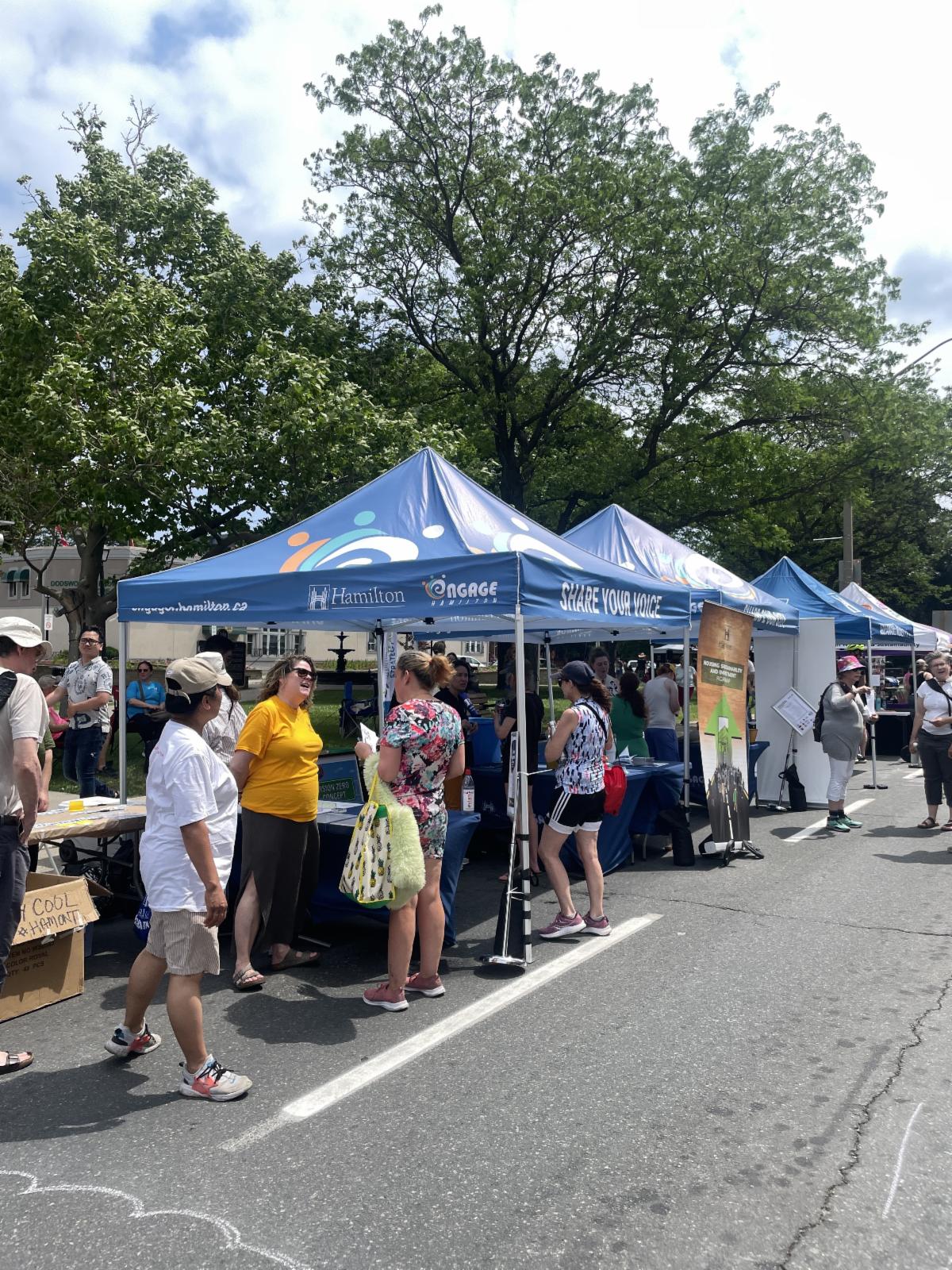 Festival goers and City staff talking at a booth