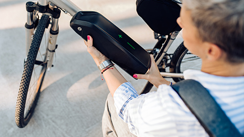 Person installing battery onto e-bike