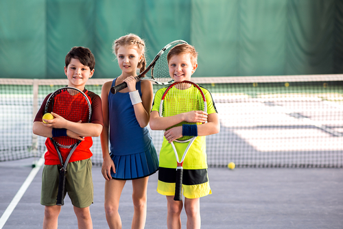 Girl and boys playing tennis with enjoyment