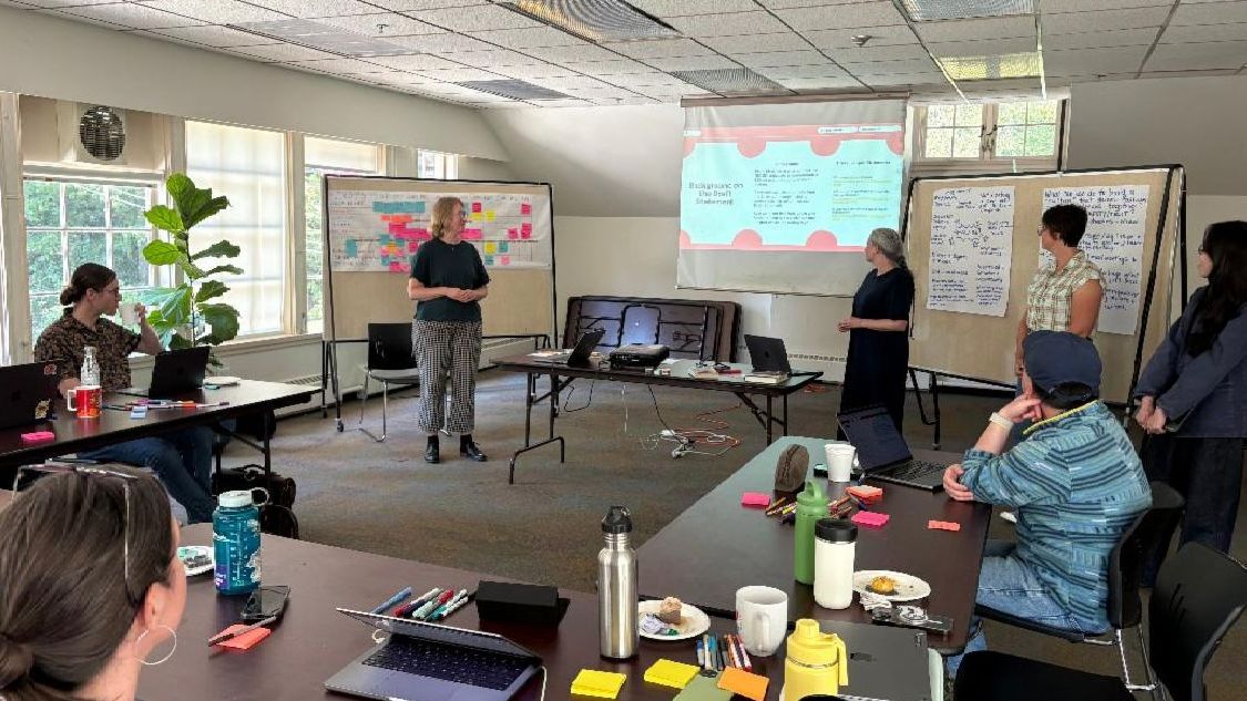 Brainstorming with two staff members standing in the middle facilitating discussion