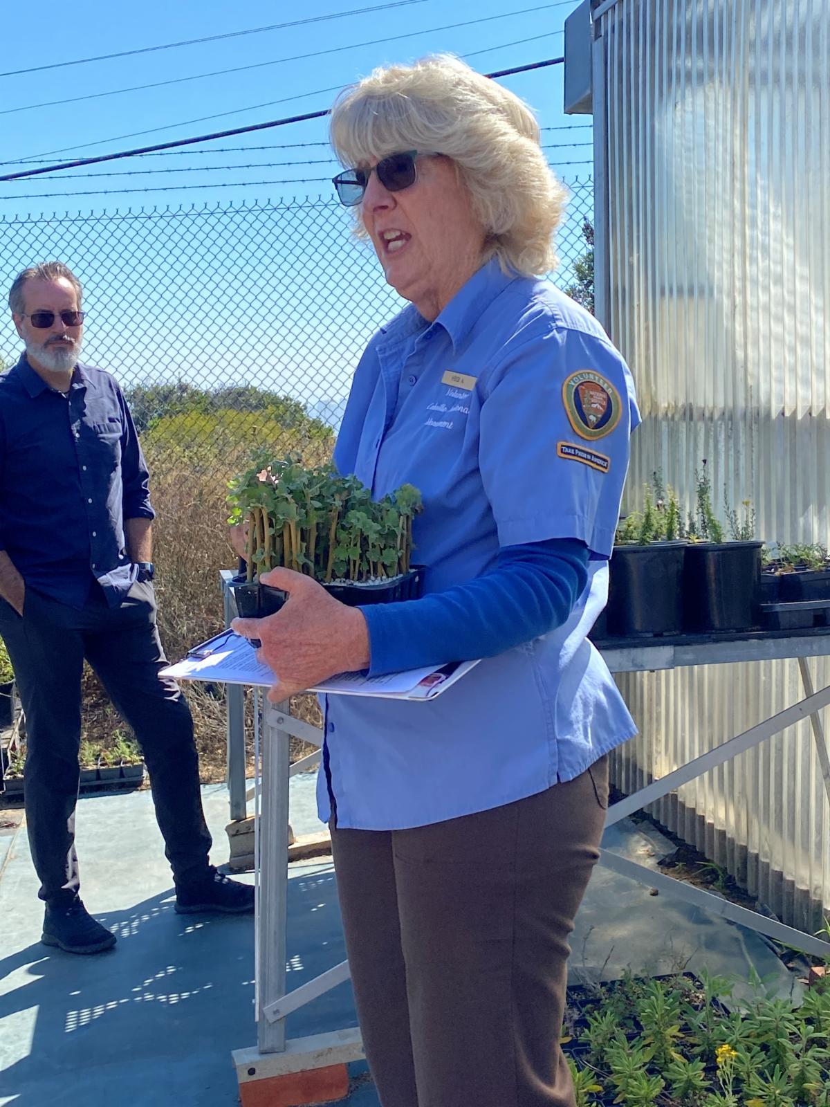 Greenhouse VIP Heide holds a tray full of young mallow plants.