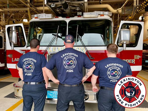 three lexington fire fighters wearing autism acceptance t shirts