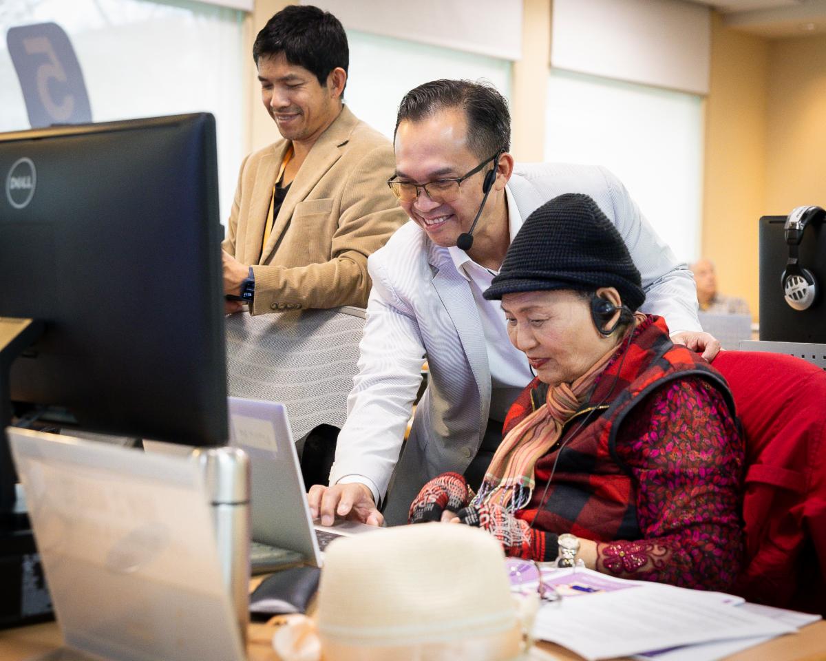 A teacher assisting a student on their laptop