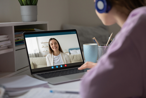Pc screen view over woman shoulder_ two girls best friends chatting using virtual modern video conference application communicating from home enjoy distant talk. Teacher teach learner remotely concept