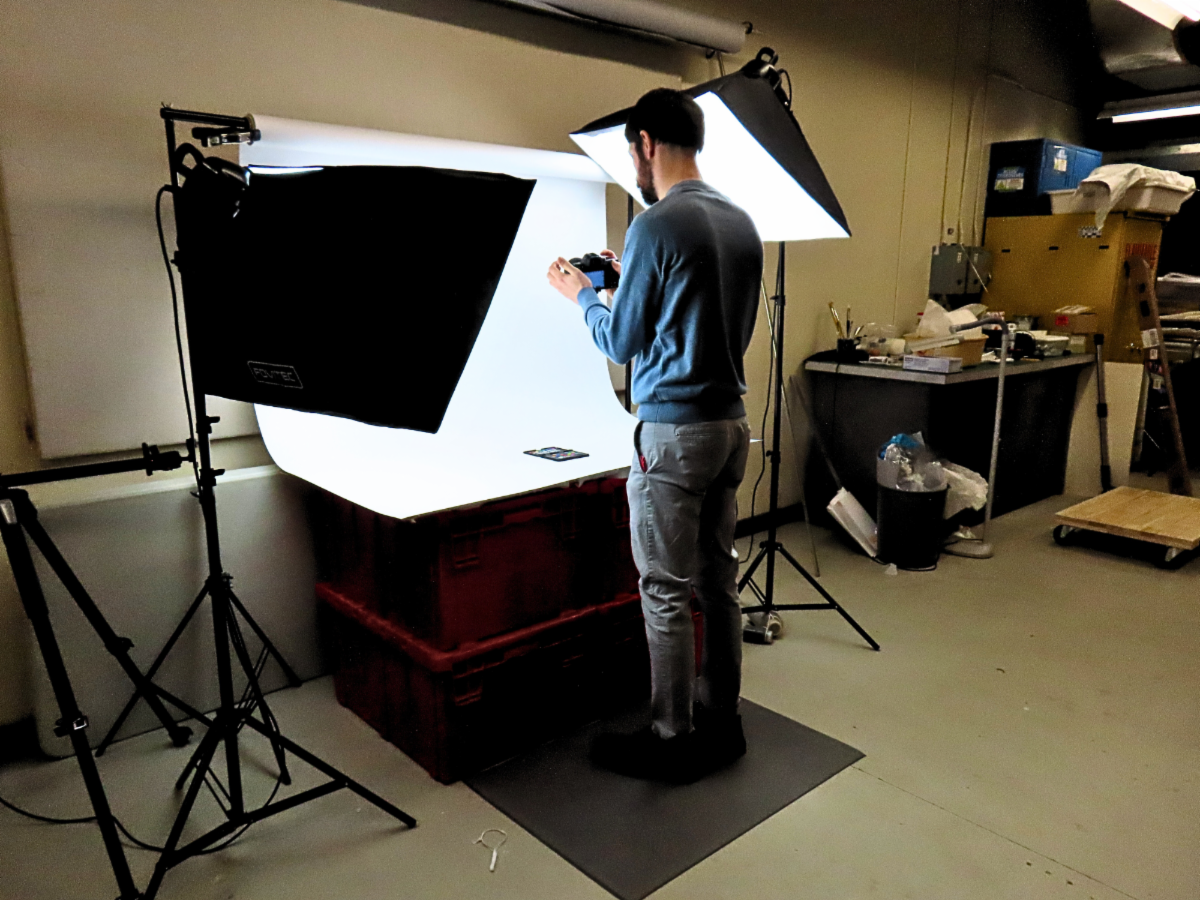 Image of Curator taking a photograph of historical artifacts.