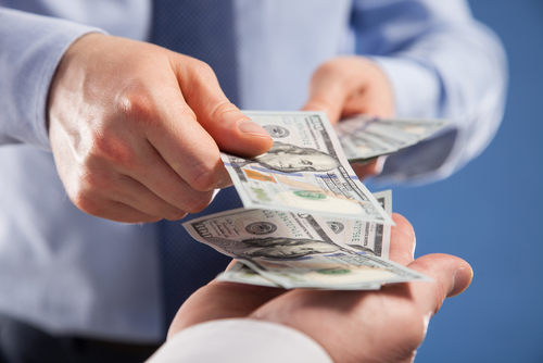 Human hands exchanging money on blue background_ closeup shot