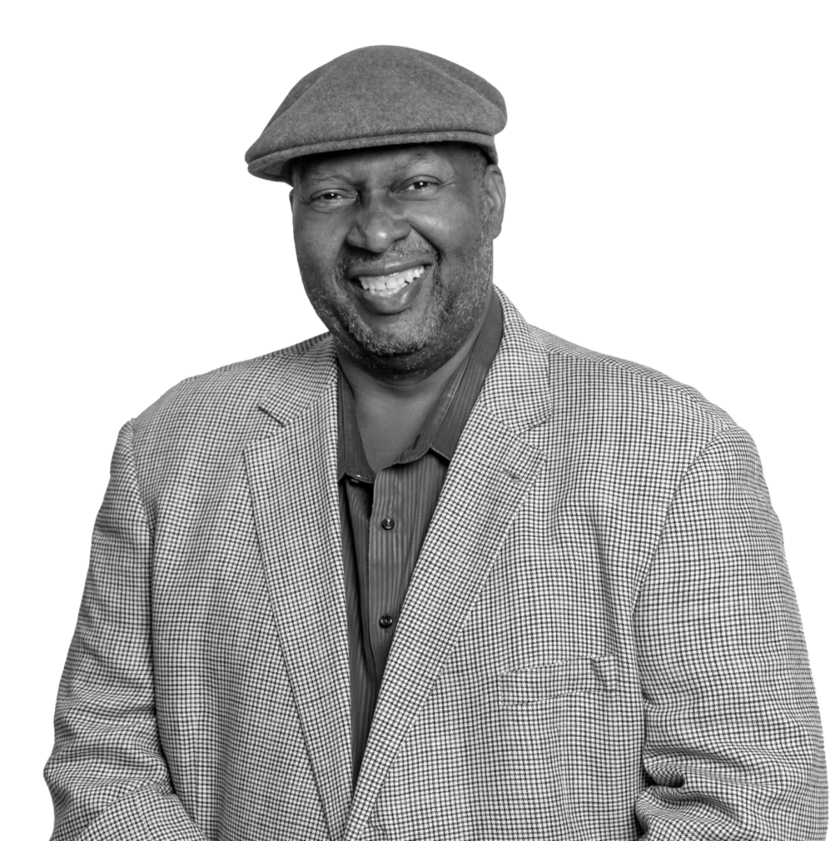 Photo of Shawn Riggins, smiling and wearing a hat, blazer,