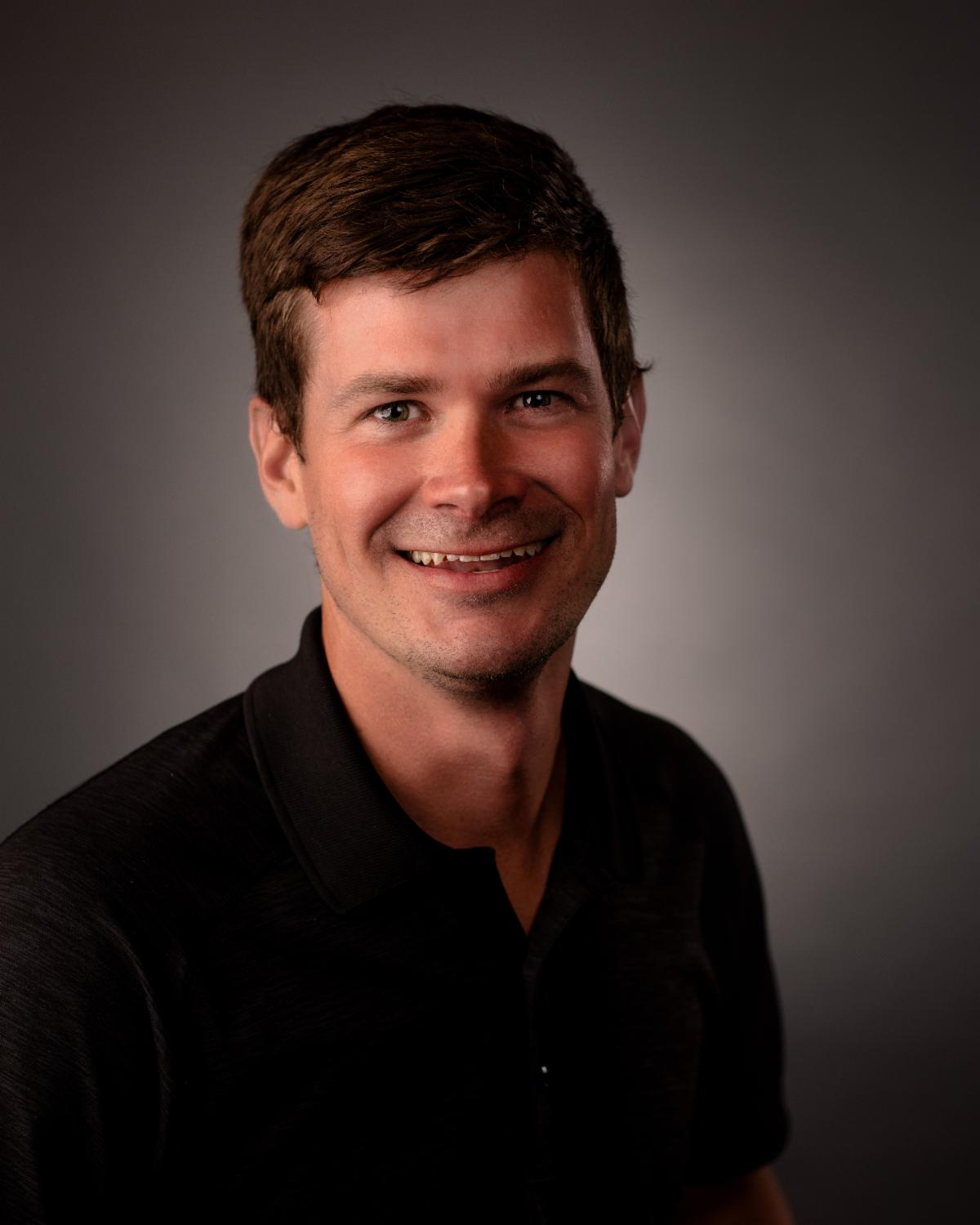 Man smiling with dark background