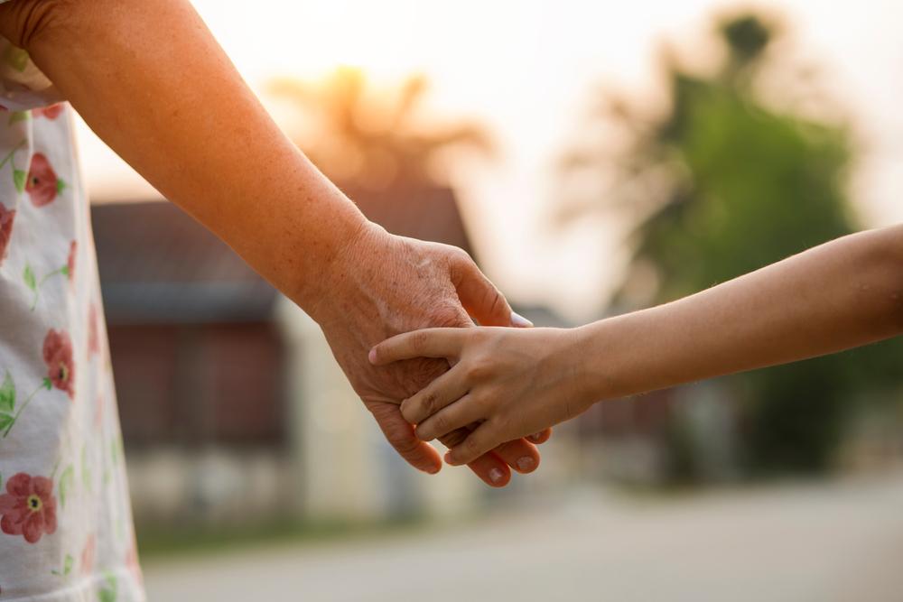 Adult and child hold hands