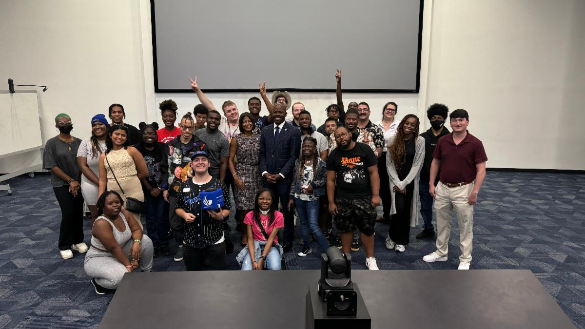 IDEAl students standing with president Blake and first lady
