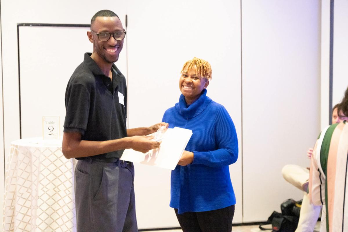 Black young man alum from IDEAL program and black woman from the career fair