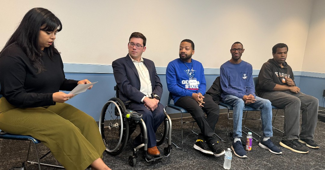 Hispanic leading panel of four men including one in wheelchair