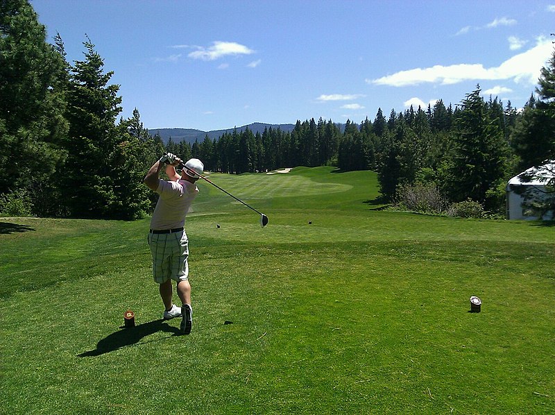 A golfer tees off