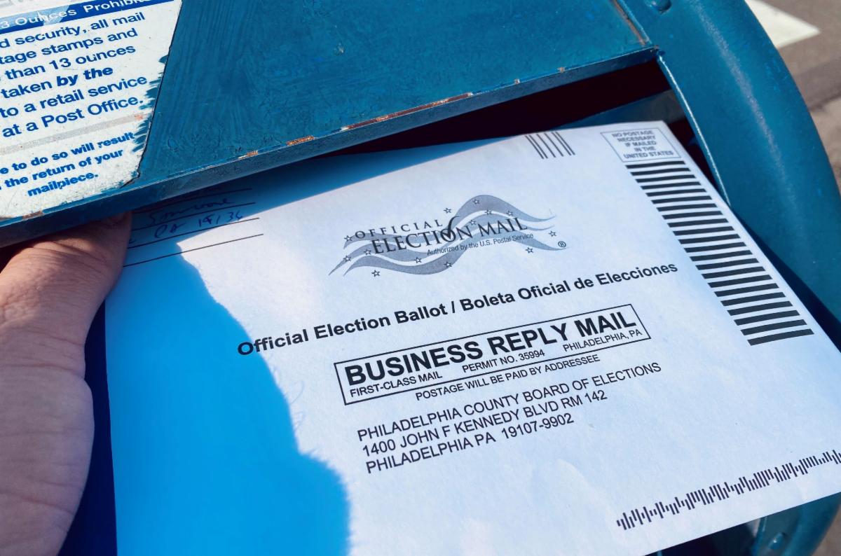 A Philadelphia voter putting a mail-in ballot in a mailbox