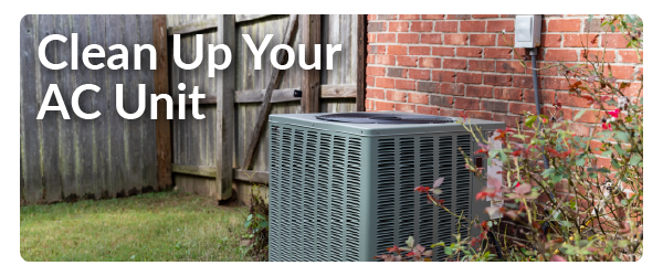 an AC unit outside against a brick wall with the words Clean Up Your AC Unit on the left side