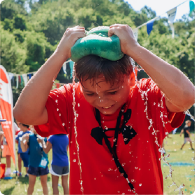 a youngster squeezing a sponge over his head