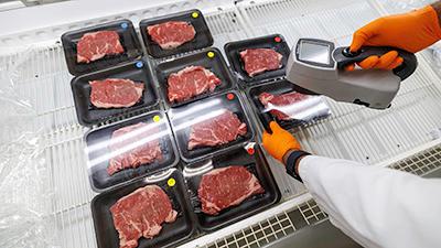 A researcher inspects packaged beef.