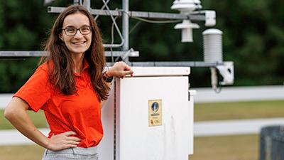 An outdoor portrait of Emma White in front of Mesonet equipment.