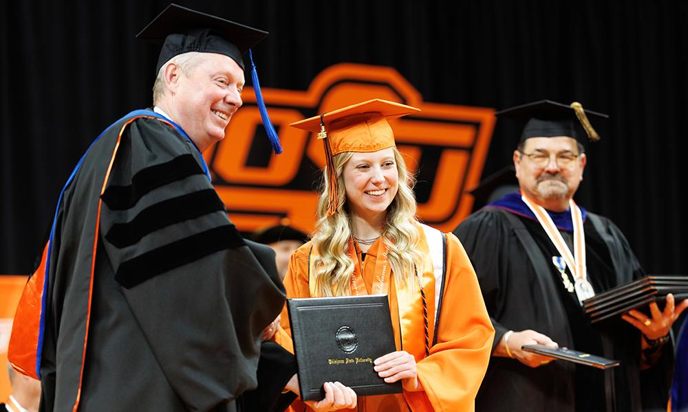 Dr. Lusk awards Jacie Wolfinger her diploma at graduation.