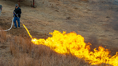 A man performs a prescribed burning.