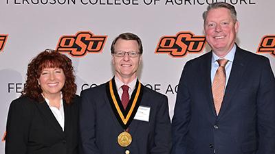 Dan Shoup stands with Dr. Clary and Dr. Lusk at an awards ceremony.