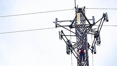 A man climbs up a network tower.