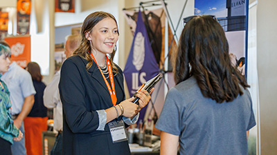 A woman talk to a student during the career fair.