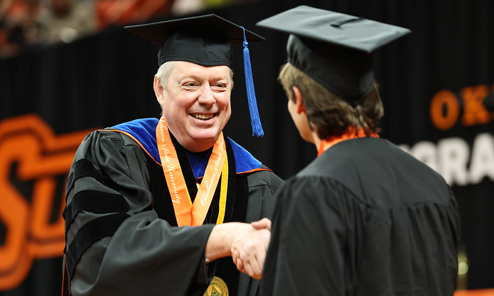 Jayson Lusk shakes hand with a student during the Fall 2025 graduation.