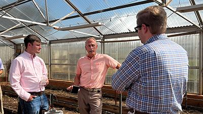 Senator James Lankford's staff stand in a greenhouse at the Agronomy Research Station.