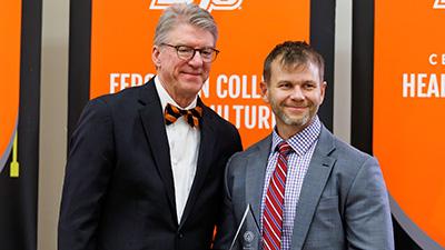 Jim Hess with Brian Whitacre in front of OSU backdrop.