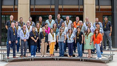Past teaching award recipients with their medals in front of Agricultural Hall.