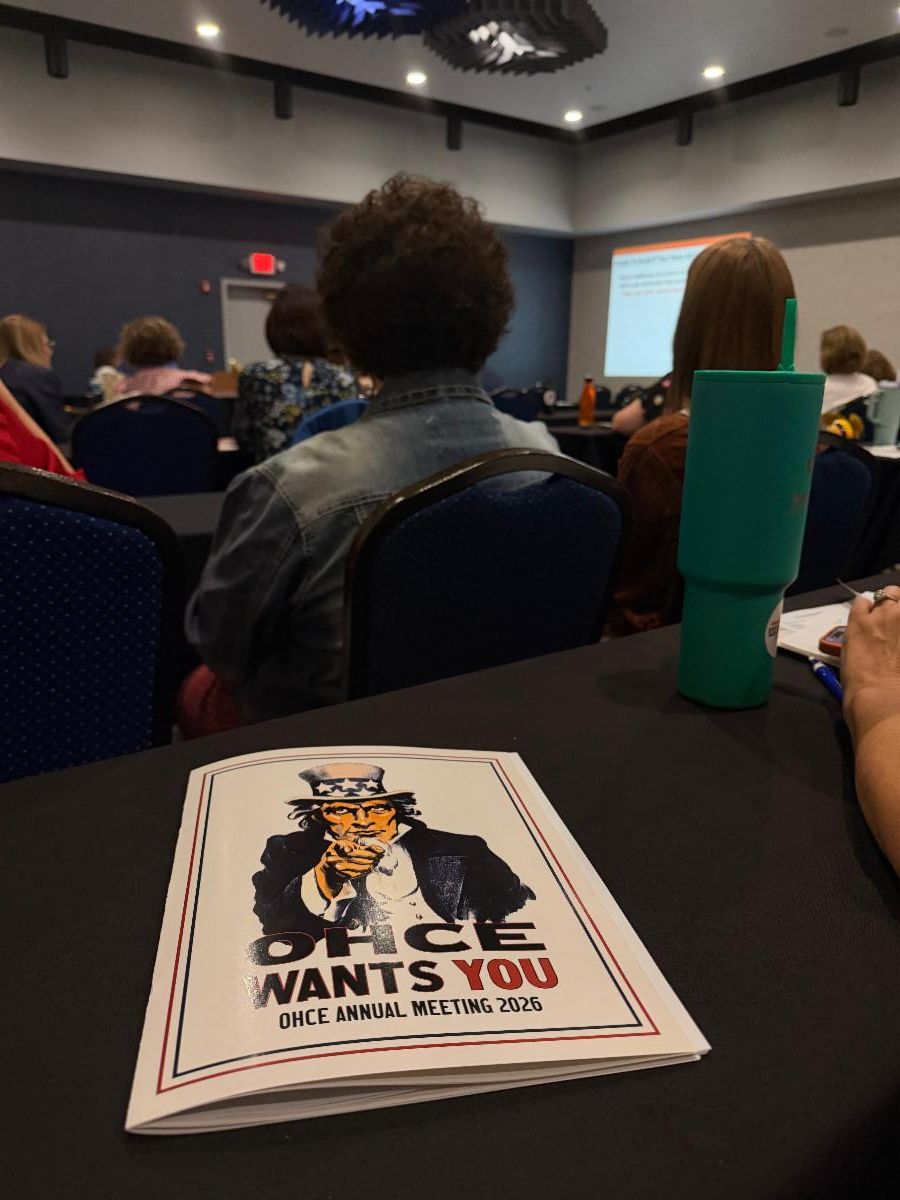 OHCE members attend an educational session during the 2026 Oklahoma Home and Community Education Annual Meeting. An event program titled “OHCE Wants You” is displayed on a conference table in the foreground.