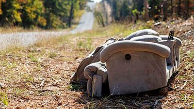 Old sofa on the ground along a road.