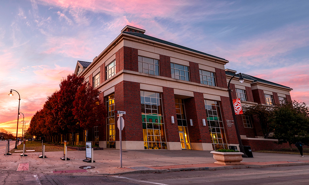 Robert M. Kerr Food and Agricultural Products Center building with a sunset in the background.