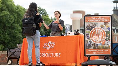 Emma White giving a Mesonet demo at a tabling event during Land-Grant Week.