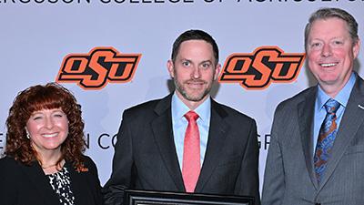 John Michael Riley receives his award with Cynda Clary and Jayson Lusk.