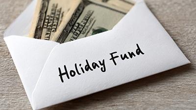 Money in an envelope labeled "Holiday Fund."