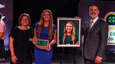 Maggie Evans and her parents with her Oklahoma 4-H Hall of Fame award.