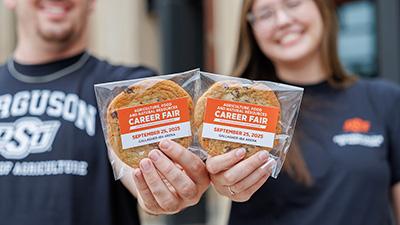 Two Ferguson College of Agriculture students holding chocolate chip cookies during Cookies and Careers event.