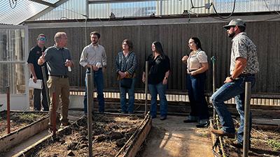 Senator Markwayne Mullin's staff standing in a greenhouse at the Agronomy Research Station.