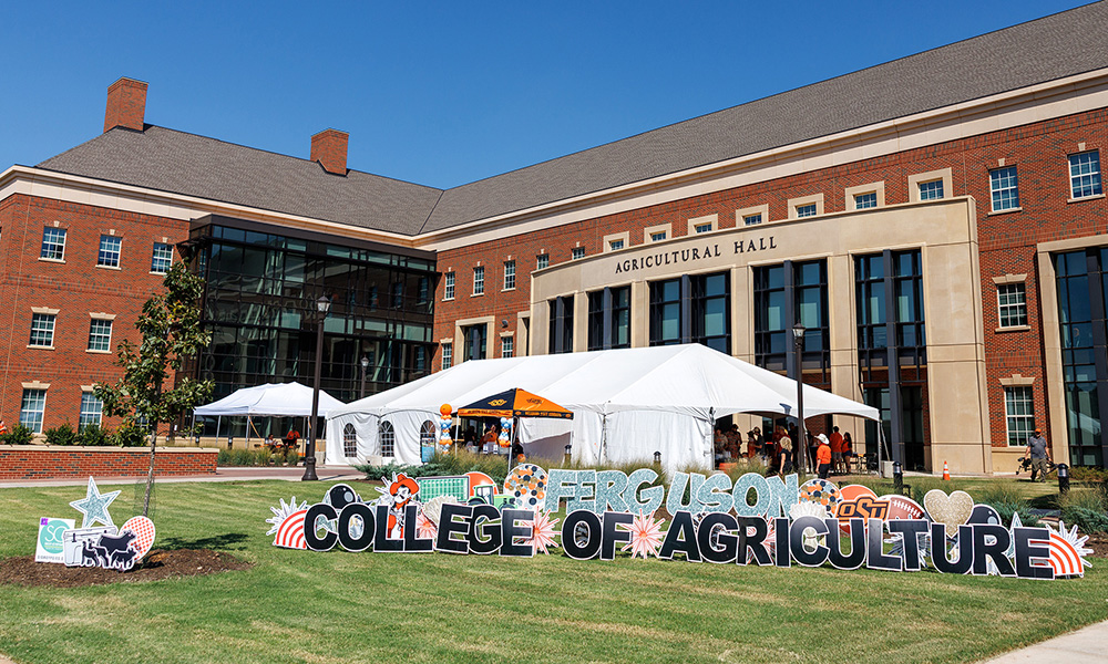 Ferguson College of Agriculture sign outside Agricultural Hall with tailgate tents in the background.