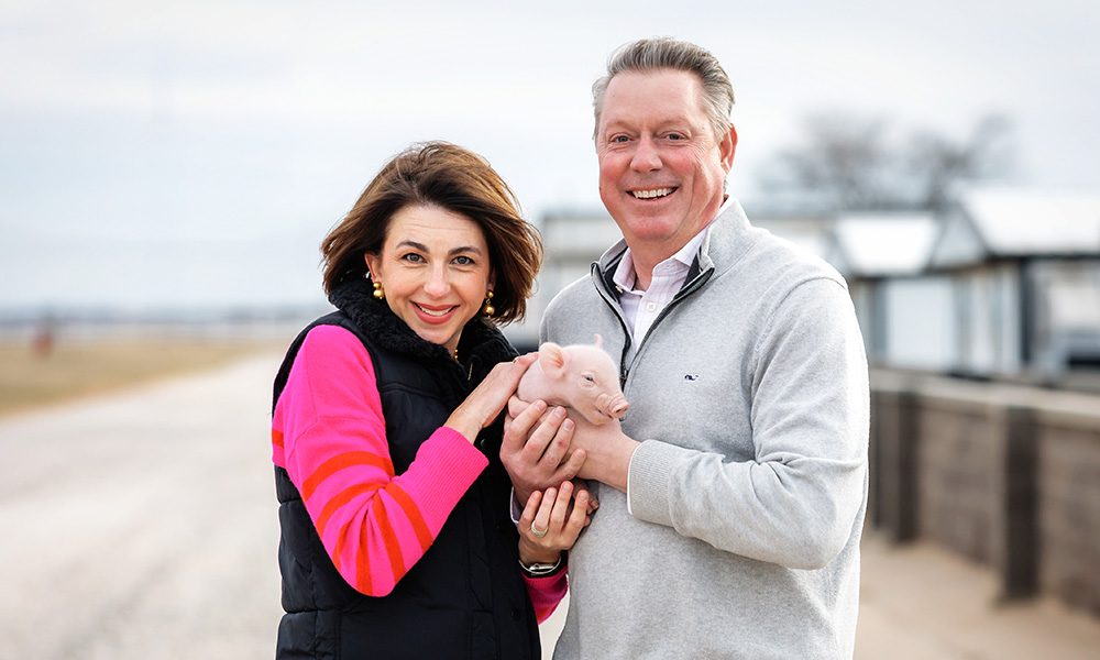 Christy and Jayson Lusk with a baby pig.