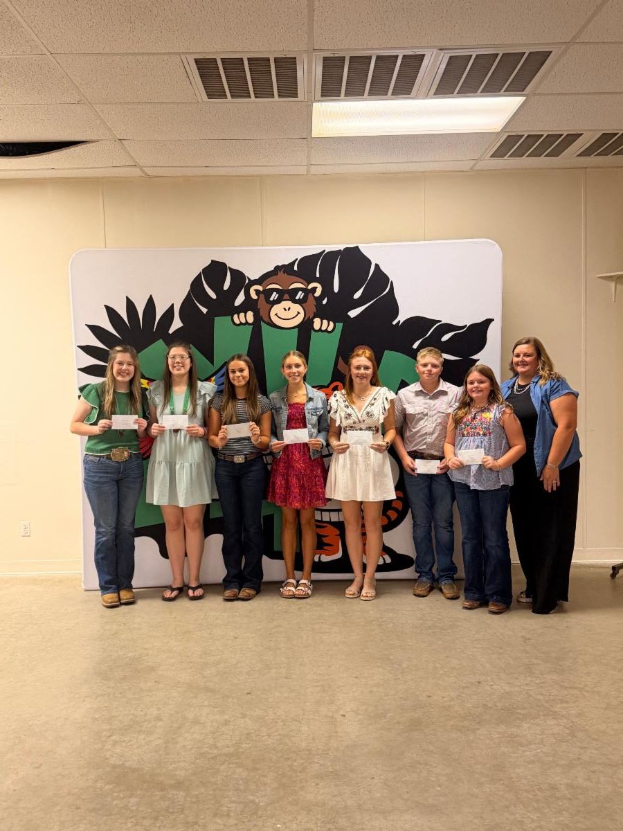 Watonga 4-H Club award winners pose with their club leader while displaying award envelopes during the Blaine County 4-H Achievement Banquet.