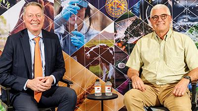 Dr. Jayson Lusk and Donnie Smith sit in front of a photo collage backdrop.