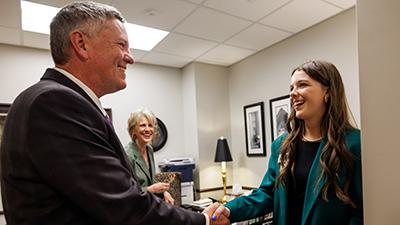 A 4-H member shakes a legislator's hand.